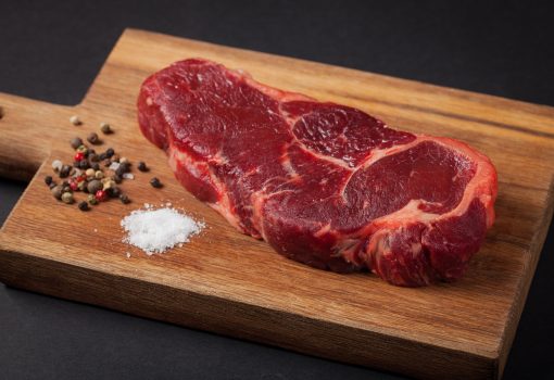 Beef steak on the wood black background with free space for text design or logotype menu restaurant Beef steak on the wood black background with free space for text design or logotype menu restaurant